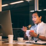 A man eats noodles at his table