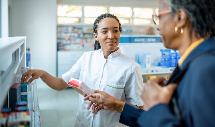 A black female pharmacist shows a Black woman some prescription drugs.